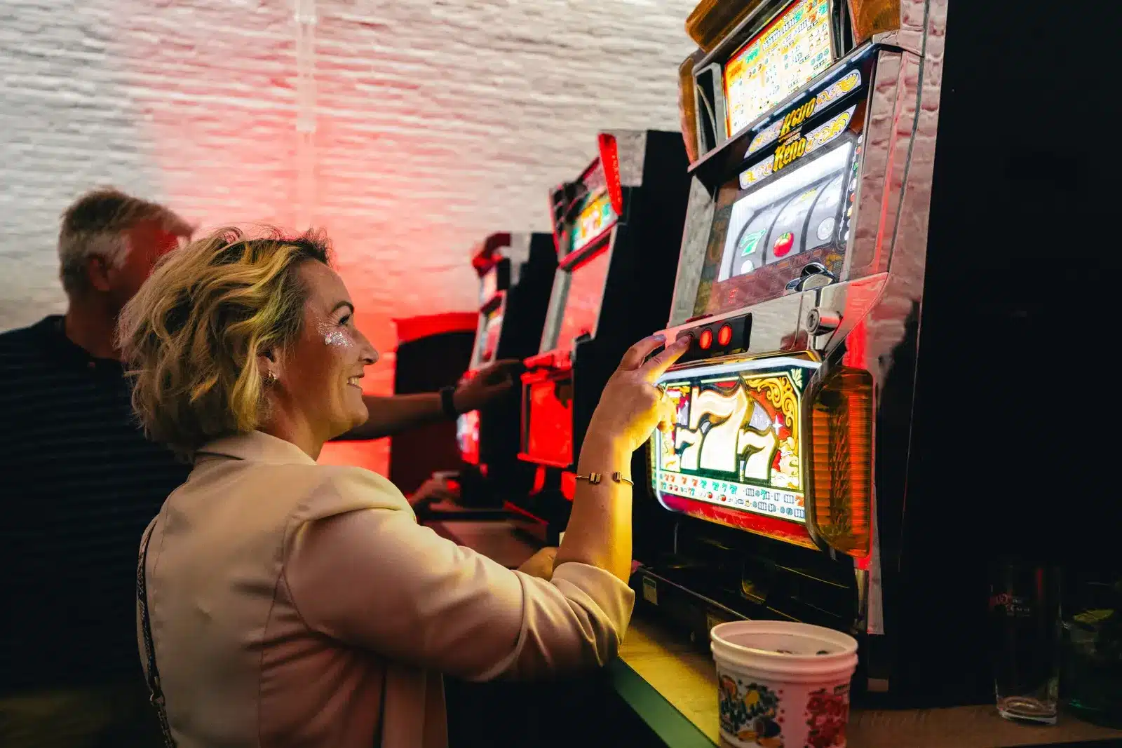 Gast speelt op een fruitmachine in rode sfeerverlichting
