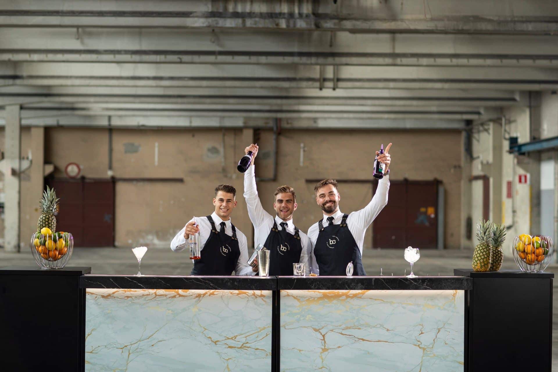 Bartenders van Bar Company juichen achter een cocktailbar