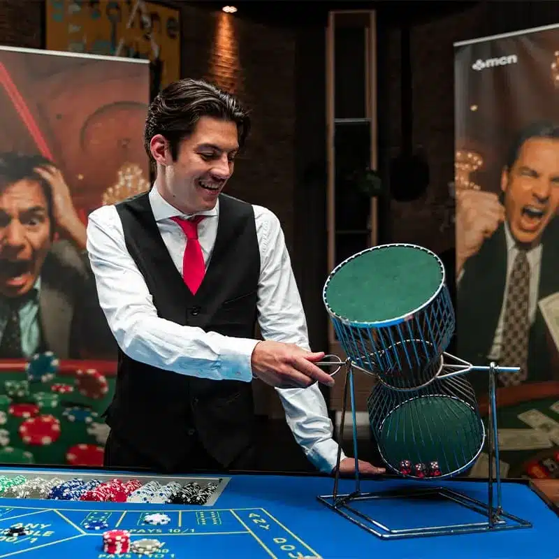 Croupier draait de dobbelkooi aan de chuck-a-luck tafel