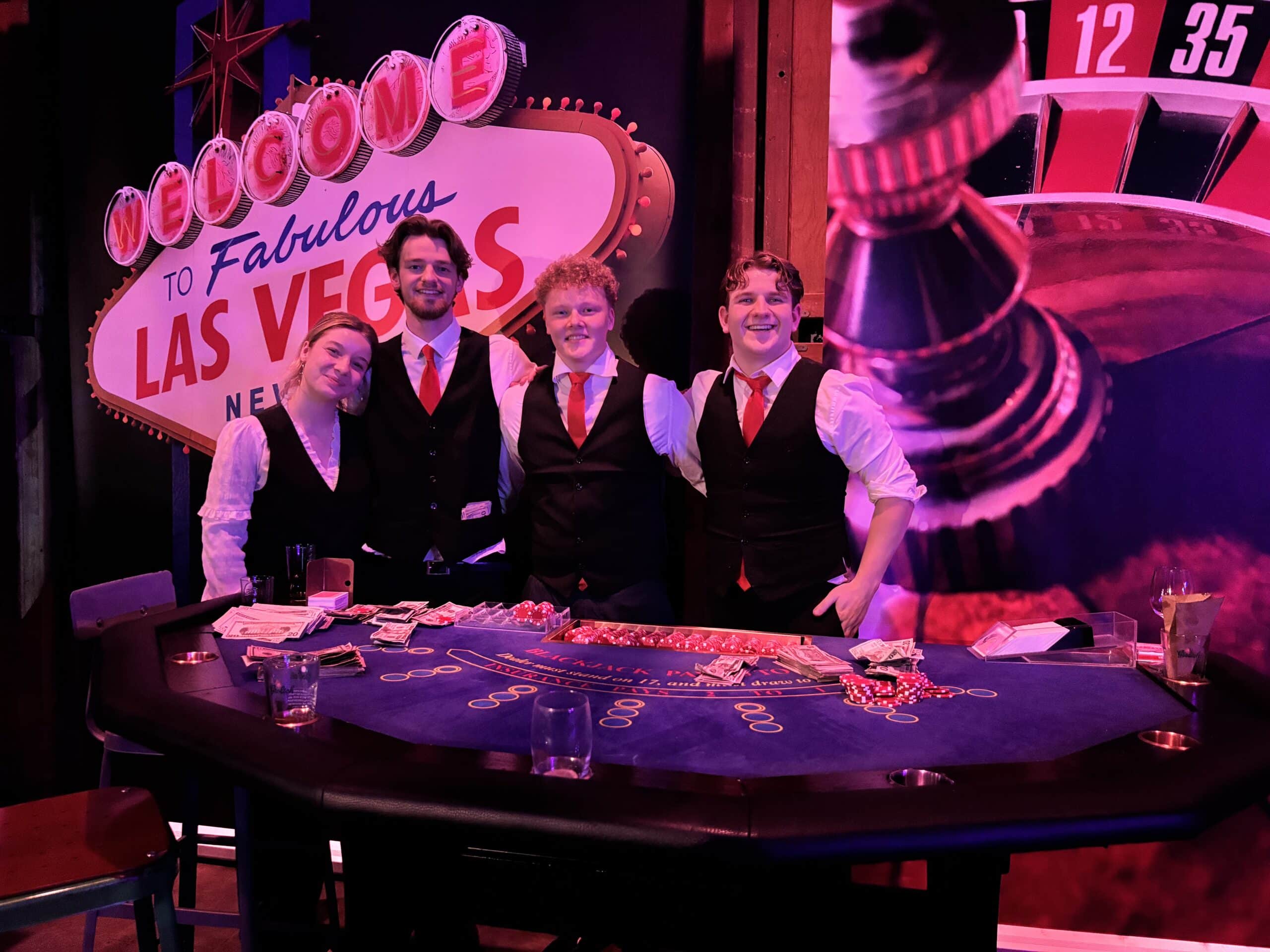 Volle zaal met casinotafels tijdens een Las Vegas themafeest