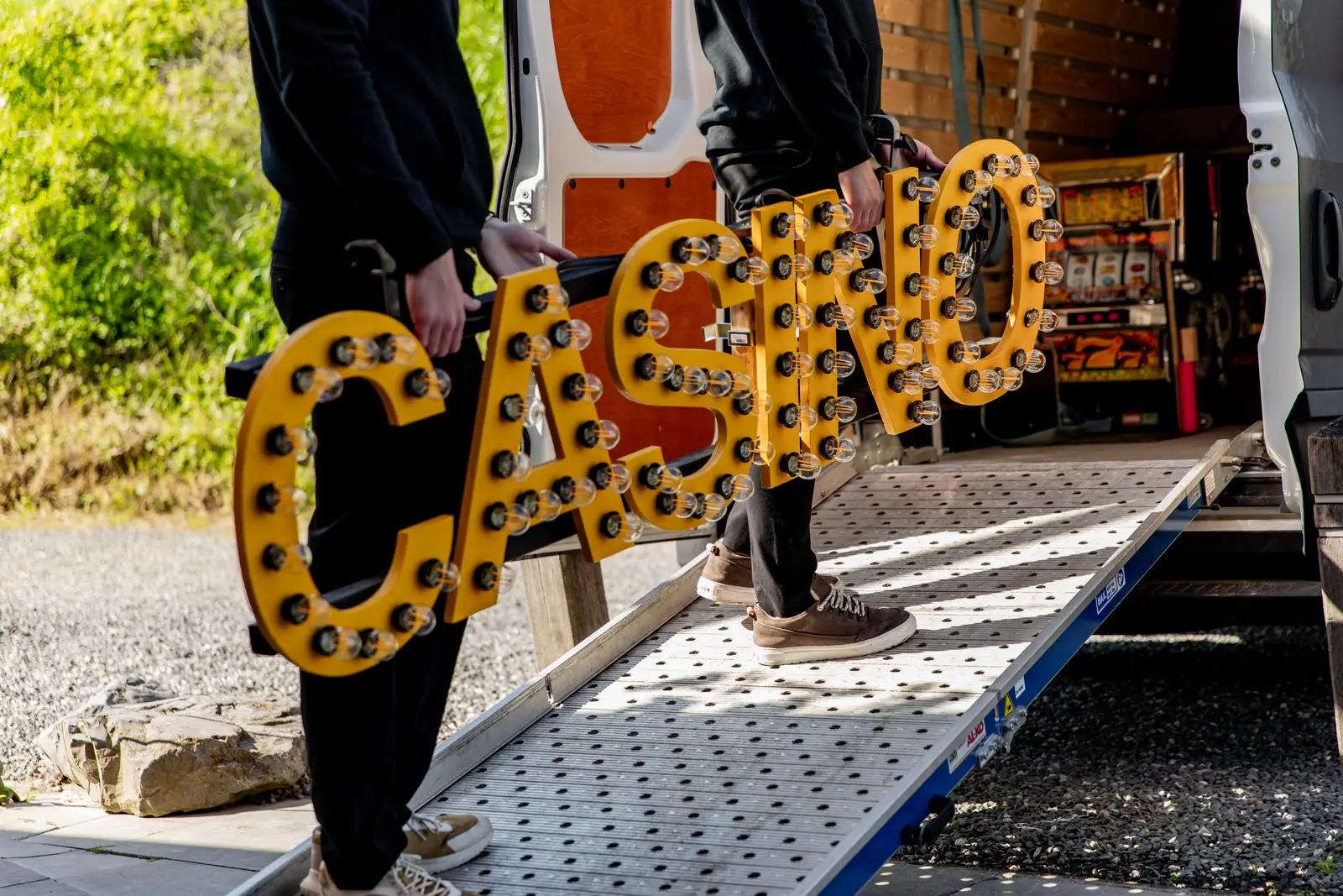 Team van MCN draagt de verlichte CASINO-letters uit de bus